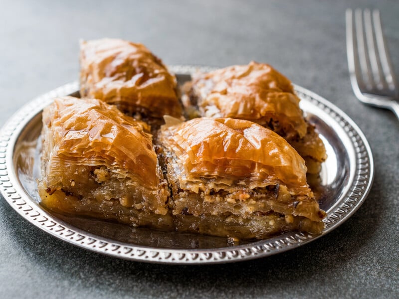 Лаваш щедро змастіть вершковим маслом, полийте медом і посипте горіхами – вийде хрустка пахлава